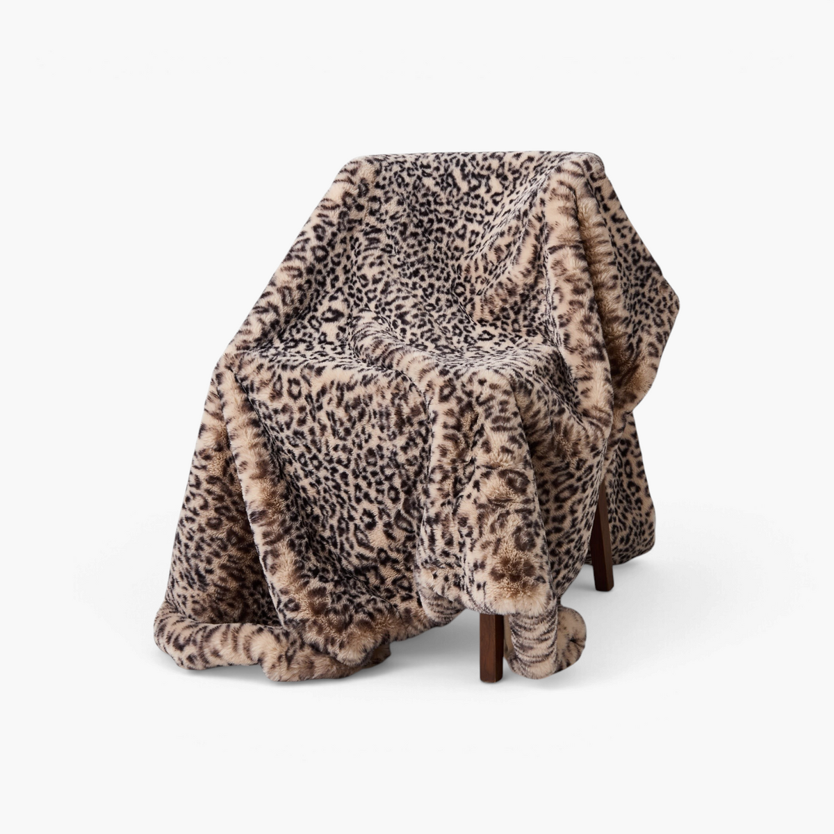 Lyckåsen cream leopard print polyester blanket draped over a chair, featuring a soft plush texture.