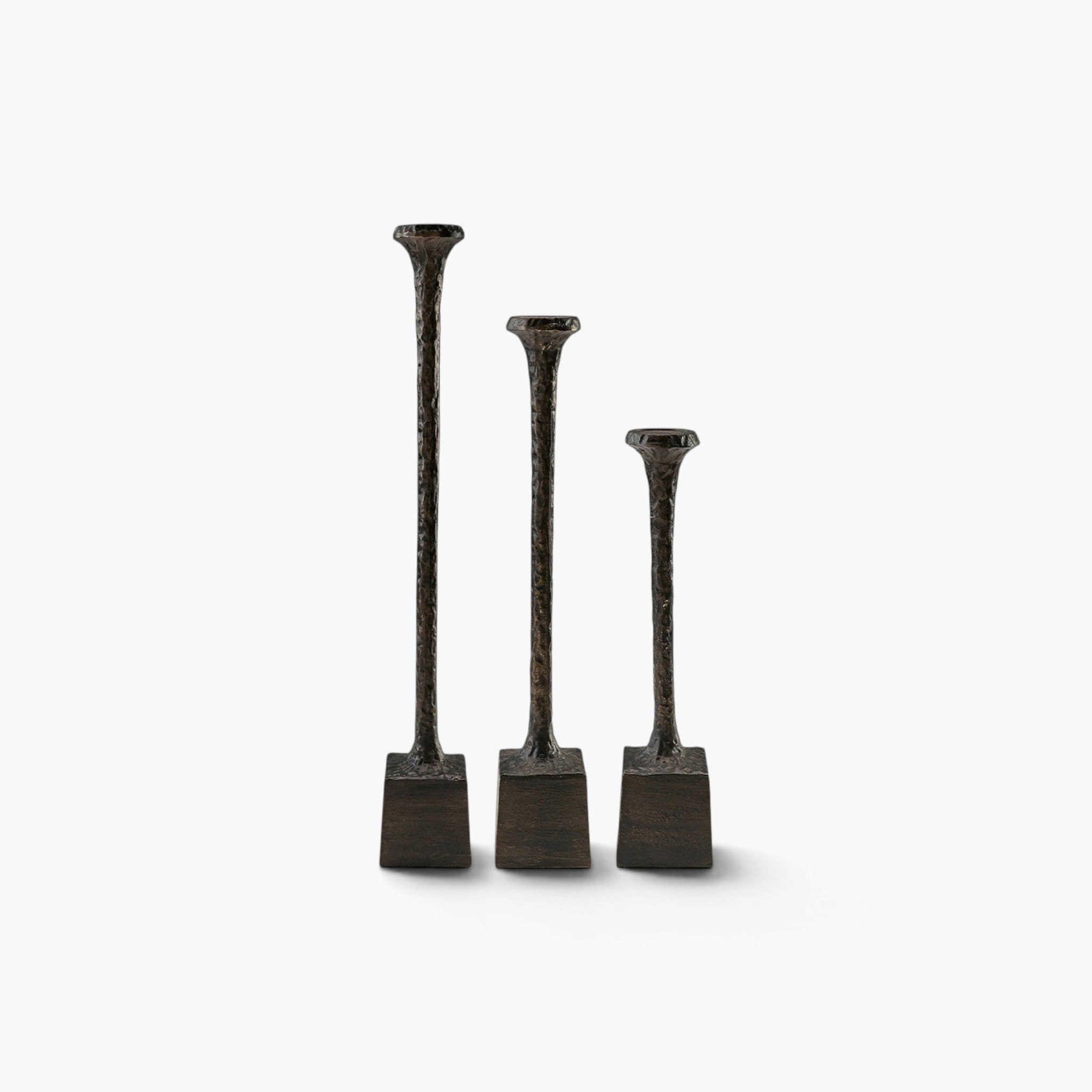 Lyckåsen set of 3 antique bronze metal candlesticks with a textured hammered finish and square bases.