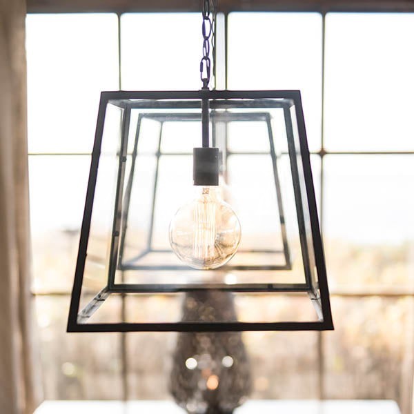 Lyckåsen Big City modern pendant lamp with a black iron frame and clear tempered glass panels hanging by a chain.