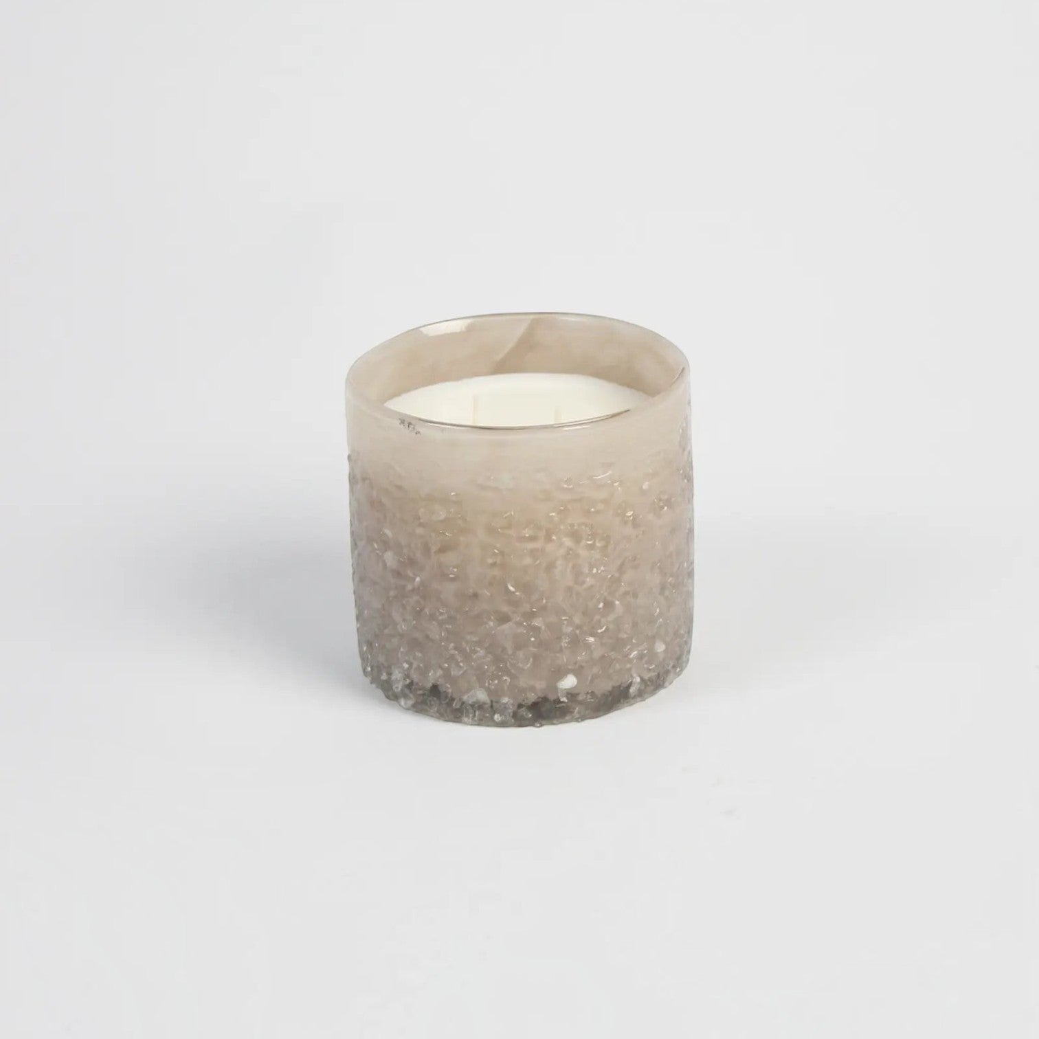 Lyckåsen Delhi Cashmere scented candle in a unique, hand-crafted textured beige glass container.