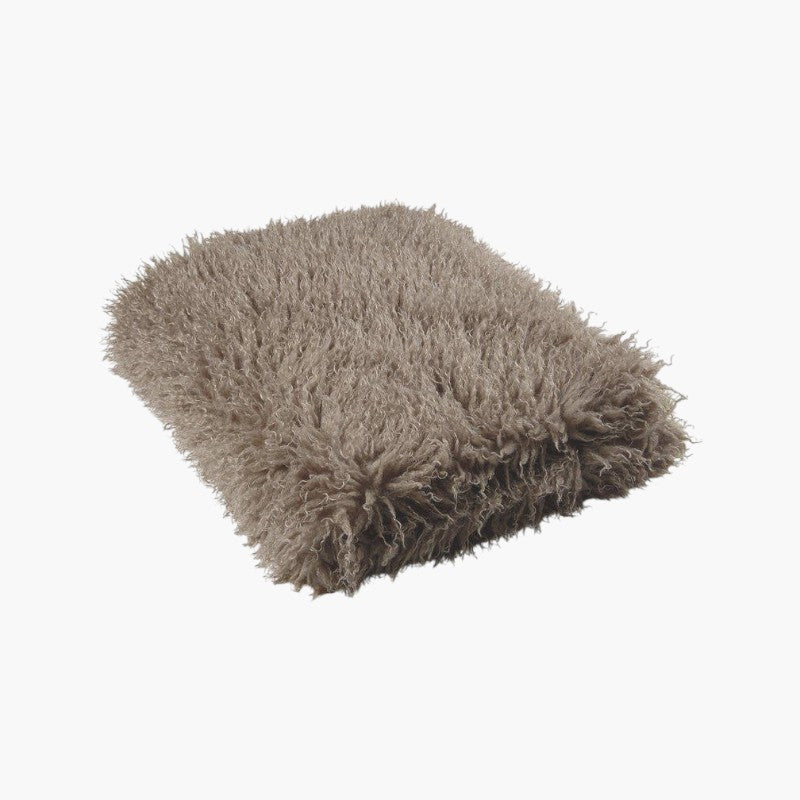 Lyckåsen sand coloured faux fur throw blanket with a curly Tibetan sheepskin texture for a cozy home interior