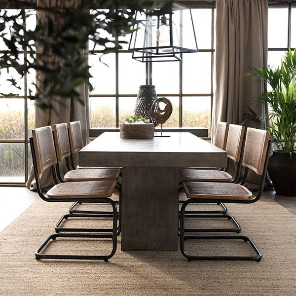 Lyckåsen Big City glass pendant lamp hanging over a modern dining table with rattan chairs in a bright living room