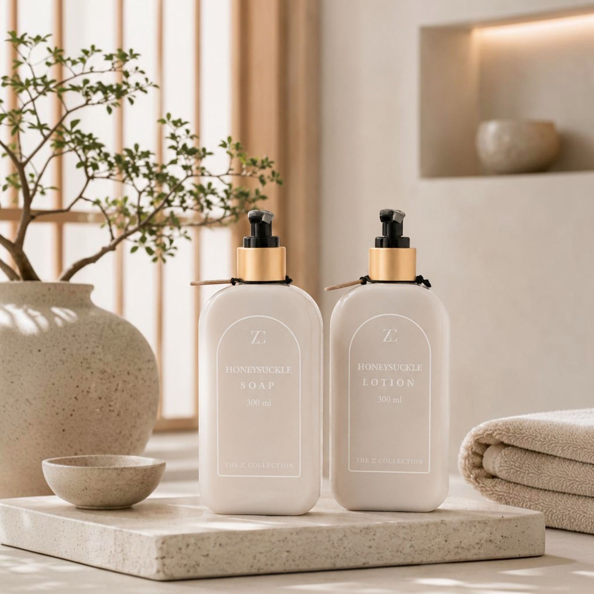 Lyckåsen Honeysuckle soap and lotion set in beige recycled plastic bottles with gold pump dispensers on a stone tray.
