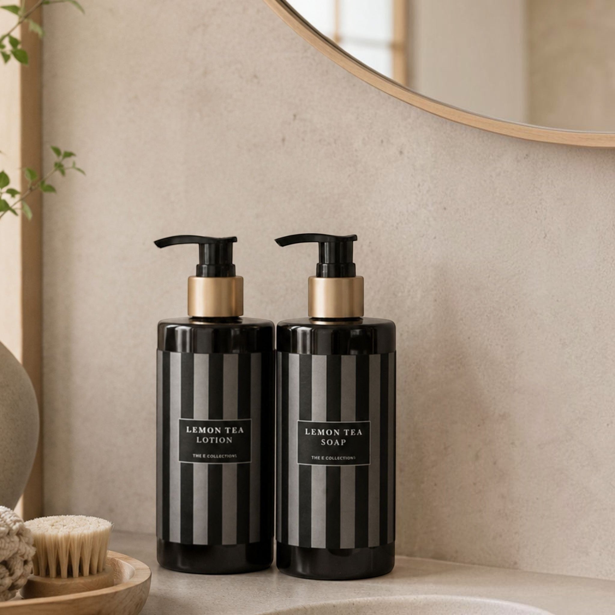 Lyckåsen Lemon Tea soap and lotion set in black striped bottles with gold accents on a bathroom counter.