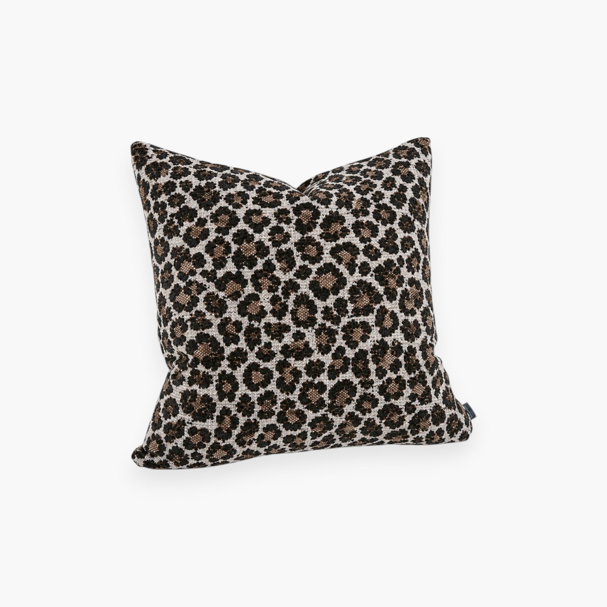 Lyckåsen Leovino cushion cover with a beige base and black and brown animal print pattern and textured woven fabric.