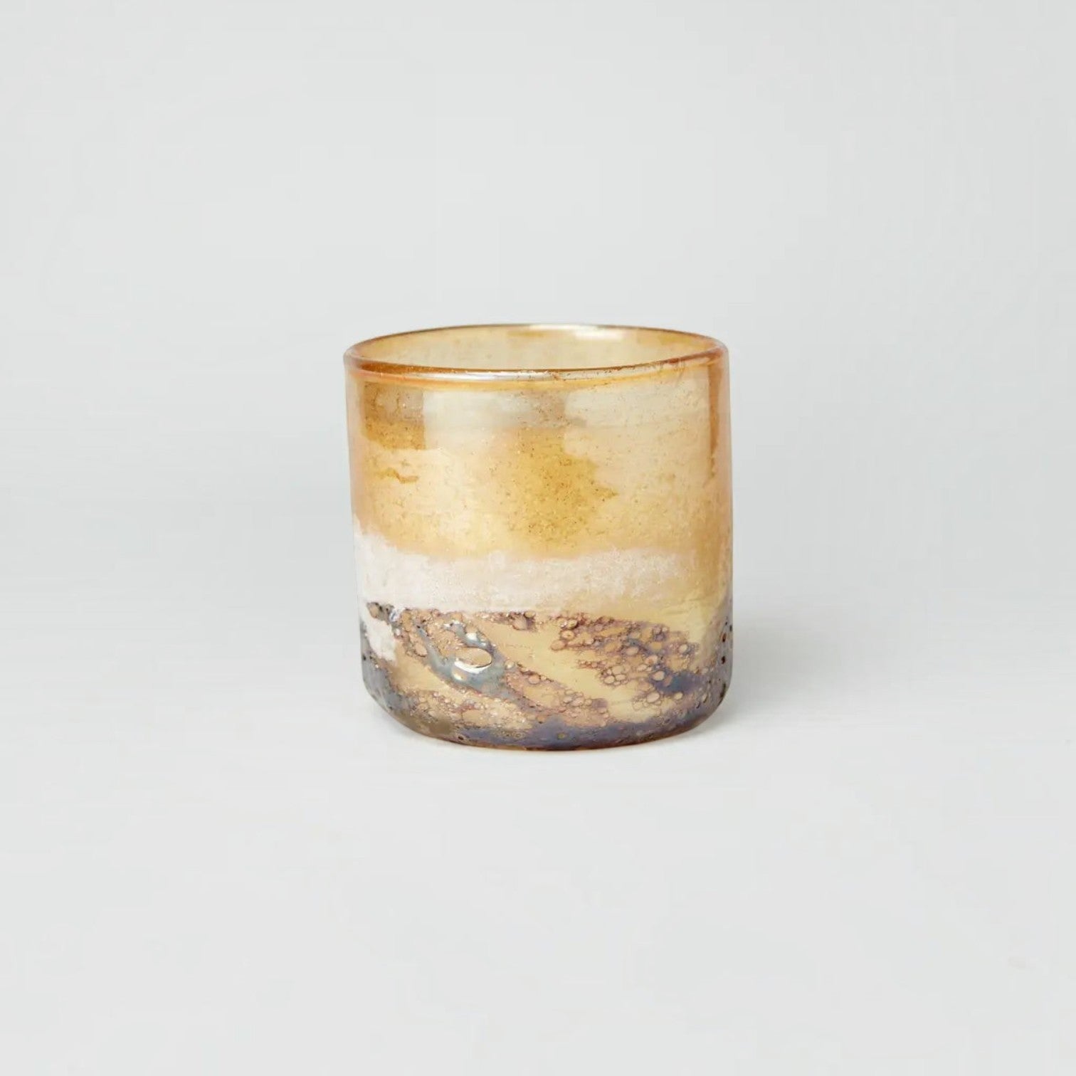Lyckåsen Monaco Cedarwood scented candle in a unique, hand-crafted amber and metallic textured glass container.
