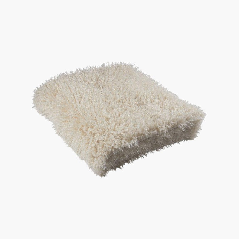 Lyckåsen off-white faux fur throw blanket with a curly Tibetan sheepskin texture and soft suede-like backing.