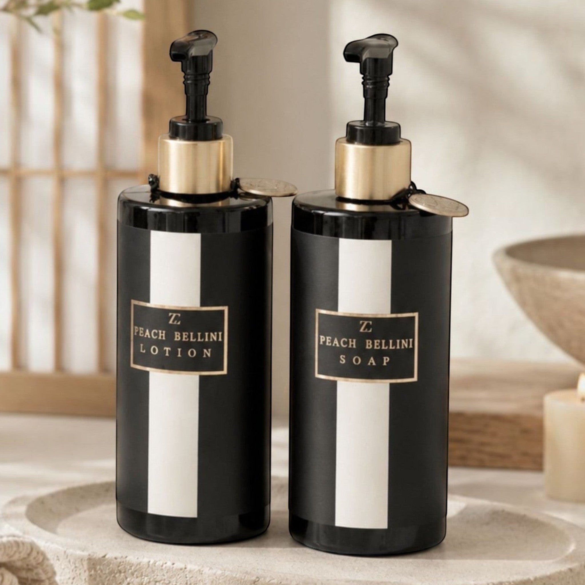 Lyckåsen Peach Bellini soap and lotion set in black bottles with gold accents on a stone tray in a bathroom setting.