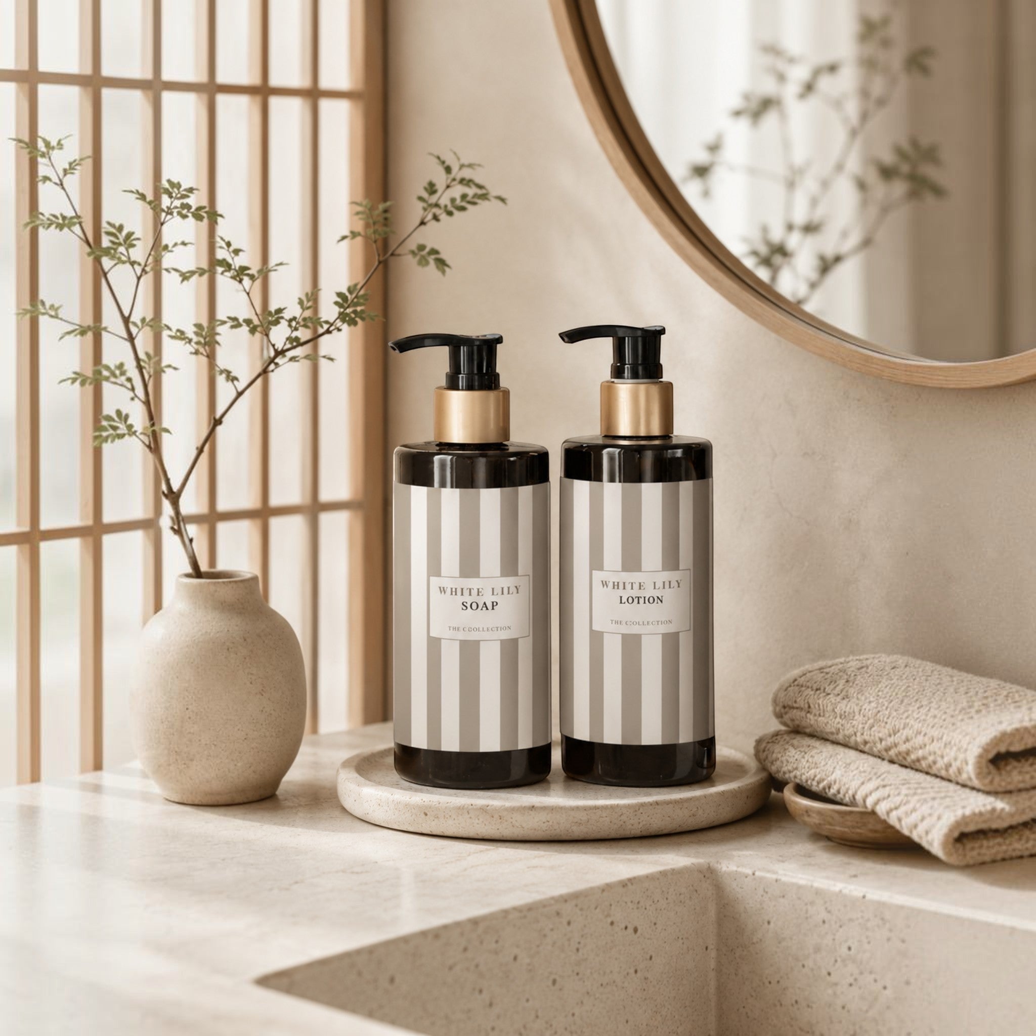 Lyckåsen White Lily lotion and soap bottles with gold accents on a stone tray in a minimalist bathroom setting.
